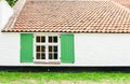 Surface vintage house background with wooden green window open, grung white brick wall and orange concrete roof tiles. Text space Royalty Free Stock Photo