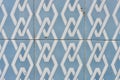 Surface of worn retro tiled background with geometrical ornate of white and blue colour in Lisbon, Portugal. Horizontal photo