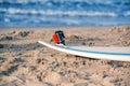 Surfboard with attached action camera lies on the sand