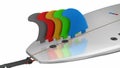 Surfboard Fins In Different Colors Over A Tail Of A Surfboard