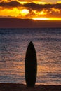 Surfboard silhouetted on Maui with fiery sky. Royalty Free Stock Photo