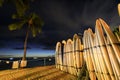 Surfboards stack on the landmark Waikiki Beach at sunset