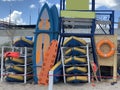 Surfboards are stacked on the shore. Beach equipment near the rescue station. Rubber boats and kayaks Royalty Free Stock Photo