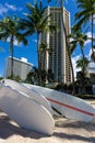 Surfboards at Waikiki beach, Honolulu, Oahu, with coconut palm trees and downtown buildings Royalty Free Stock Photo