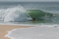 Surfer arriving at the shore of Nazare, Portugal after the ride Royalty Free Stock Photo