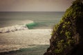 Surfer on a barrel wave getting tubed on his surfboard