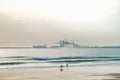 Surfer on the beach with industrial background Royalty Free Stock Photo