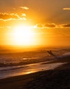 Surfer on the beach running during the sunset Royalty Free Stock Photo