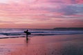 Surfer on the beach during sunset Royalty Free Stock Photo