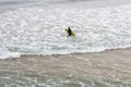Surfer with board in waves. Unknown girl from back with yellow surferboard on beach. Active lifestyle. Extreme sport.