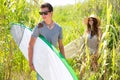 Surfer boy and girl walking in the green jungle Royalty Free Stock Photo