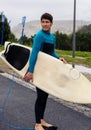 Surfer walking with surfboard to the beach, vertical photo Royalty Free Stock Photo