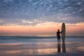 Longboard surfer silhouette at golden sunset