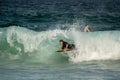 Surfer catching a wave at the beach on a sunny day at Manly Beach, Australia.