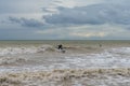 Surfer on a choppy wave in the stormy seas of the English Channel in East Sussex