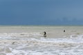 Surfer on a choppy wave in the stormy seas of the English Channel in East Sussex