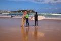 Surfer couple carrying their surfboard on the beach