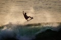 Surfer doing air reverse at Uluwatu at sunset. Extreme sports. Lifestyle. Bali, Indonesia.