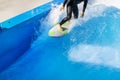 A Surfer Enjoying The Crests Of The Waves In An Urban Wave Pool In His Black Wetsuit