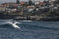 Surfer entering a huge blue barrel in the sea under a clear sky at daytime Royalty Free Stock Photo