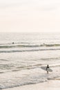 A surfer enters the Pacific Ocean, in Newport Beach, Orange County, California Royalty Free Stock Photo