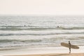 A surfer enters the Pacific Ocean, in Newport Beach, Orange County, California
