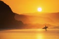Surfer exiting water at sunset Royalty Free Stock Photo