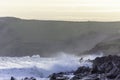 Surfer getting out of the water after evening surf in rough sea