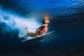 Surfer girl dive with surfboard under wave in transparent Pacific ocean Royalty Free Stock Photo