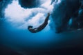 Surfer girl dive underwater with ocean powerful and dangerous wave