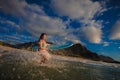 Surfer girl having fun running into sea water with drops Royalty Free Stock Photo