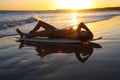 Surfer girl on her board at sunset