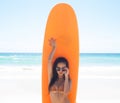 Surfer girl posing with her surfboard on the beach Royalty Free Stock Photo