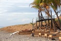 Surfer girl resting on a sun lounger under the palm trees overlooking the ocean during the sunrise