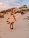 Surfer girl with surfboard on beach and warm sunset. Attractive surfer women Royalty Free Stock Photo