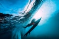 Surfer girl with surfboard dive underwater with fun under big ocean wave.