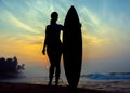 Surfer girl surfing looking at ocean beach sunset. Silhouette w Royalty Free Stock Photo