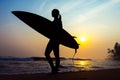 Surfer girl surfing looking at ocean beach sunset. Silhouette w Royalty Free Stock Photo