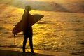 Surfer girl surfing looking at ocean beach sunset. Silhouette w Royalty Free Stock Photo