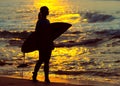 Surfer girl surfing looking at ocean beach sunset. Silhouette w Royalty Free Stock Photo