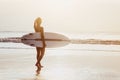 Surfer girl surfing looking at ocean beach sunset Royalty Free Stock Photo