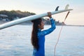 Surfer Girl. Surfing Woman Holding White Surfboard On Head. Brunette In Blue Wetsuit Going To Surf In Ocean At Sunset.