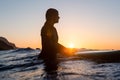 Surfer girl waiting for a wave in the water at sunset Royalty Free Stock Photo