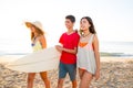 Surfer girls with teen boy walking on beach shore Royalty Free Stock Photo