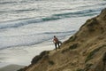 Surfer with his surf standing at the cliff and looking at the waves. Royalty Free Stock Photo