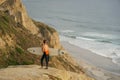 Surfer with his surf standing at the cliff and looking at the waves. Royalty Free Stock Photo