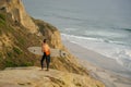 Surfer with his surf standing at the cliff and looking at the waves. Royalty Free Stock Photo