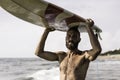 Surfer holding his surfboard on the head - Hipster man standing on the beach and waiting big waves for surfing - Fit bearded man Royalty Free Stock Photo