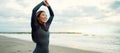 Surfer, Japanese and woman stretching at beach, happy for fitness and extreme sports with ocean view, waves and travel Royalty Free Stock Photo