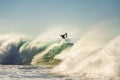 Surfer jumping a powerful and big wave at sunset Royalty Free Stock Photo